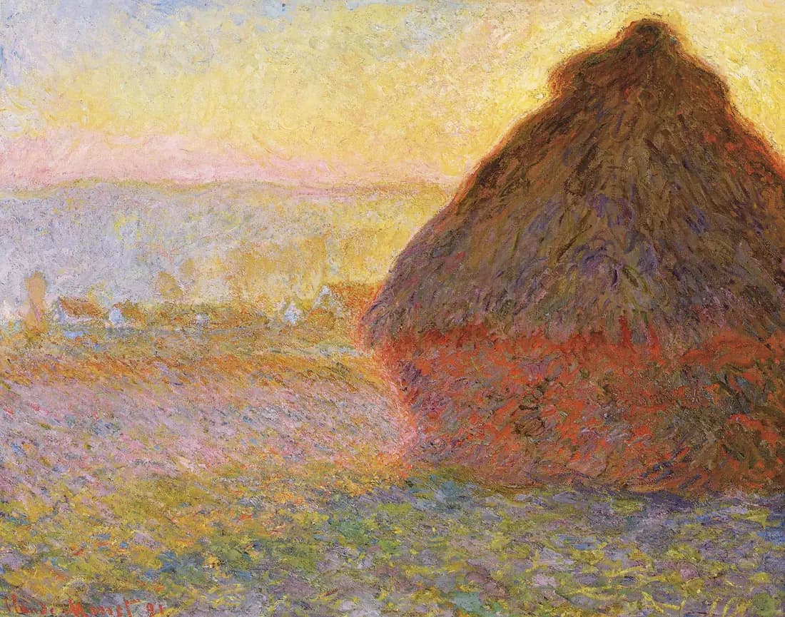 A conical grainstack glows orange and violet in low winter sunset light