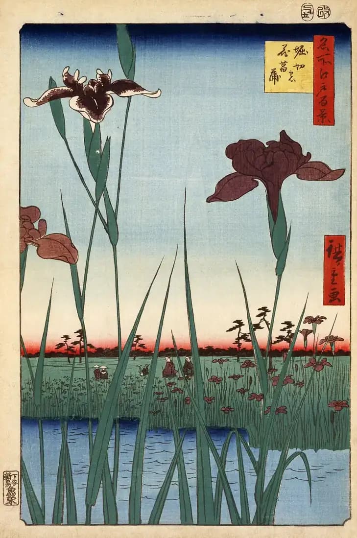 Large blue and white irises fill the foreground while visitors walk through the distant garden